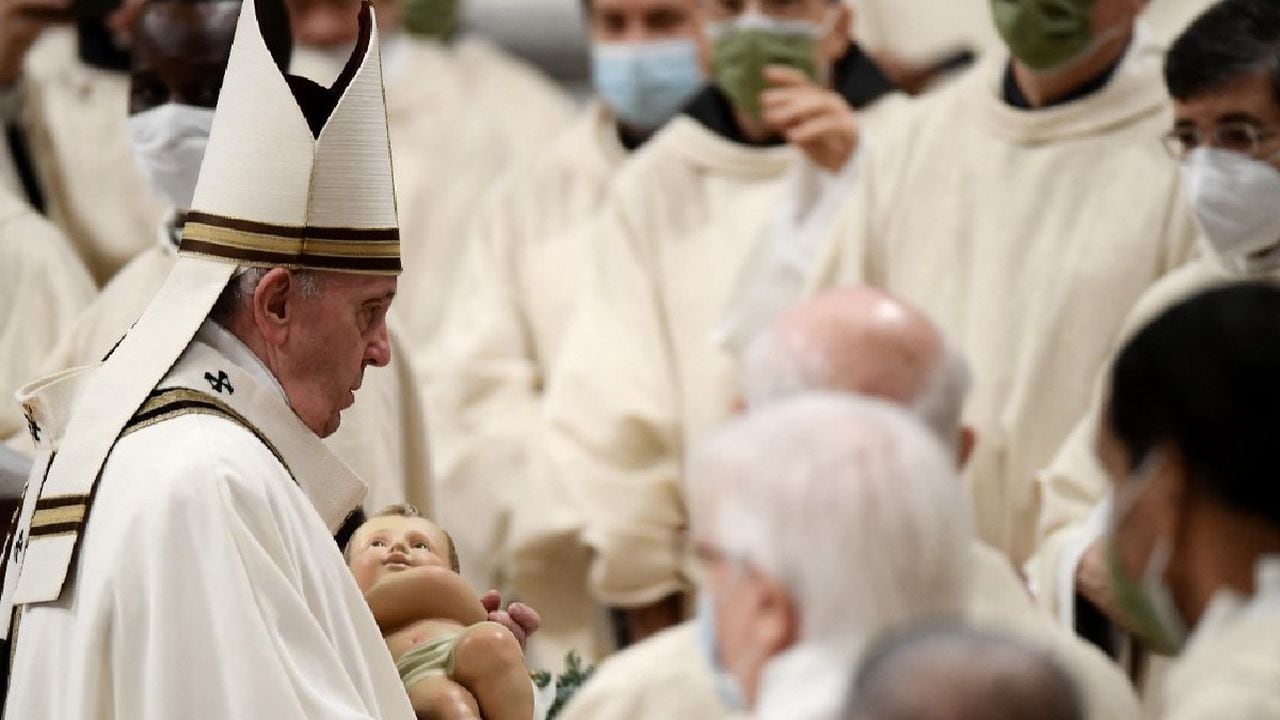 El Papa Francisco sostiene una figura del niño Jesús durante la misa de Nochebuena en la basílica de San Pedro en el Vaticano.