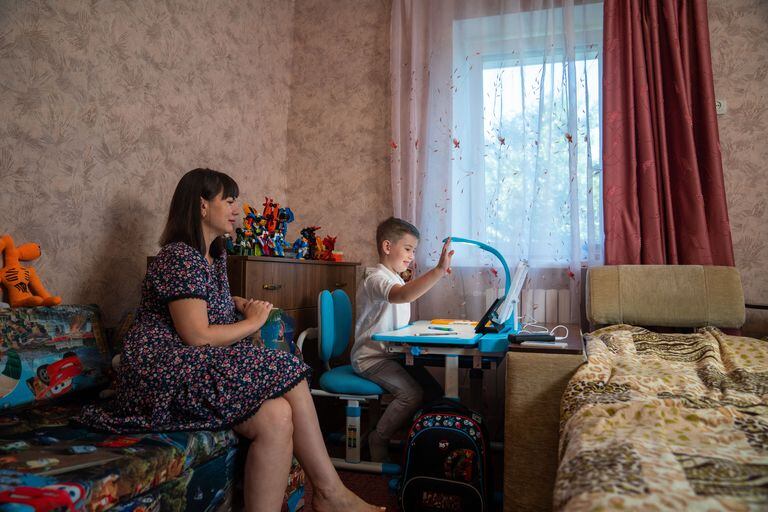 Misha Korolev, de 6 años, junto a su madre Anna Korolev, refugiados de Kharkiv, la segunda ciudad de Ucrania, asisten a una lección en línea durante el primer día de clases en Poltava el 1 de septiembre de 2022, en medio de la invasión rusa de Ucrania. - Las autoridades ucranianas dijeron que 2.199 instituciones educativas habían resultado dañadas como resultado de bombardeos y bombardeos, con 225 de ellas completamente destruidas. La mitad de las 23.000 escuelas encuestadas por el Ministerio de Educación, alrededor del 51 por ciento, están equipadas con las instalaciones de búnker necesarias para comenzar las clases fuera de línea. (Foto de Igor Tkachov / AFP)