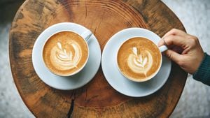 Two cups of aromatic coffee cappuccino or latte on a wooden table. person holds a cup with hand. Concept of meeting or relaxing. Tasty morning drinks.