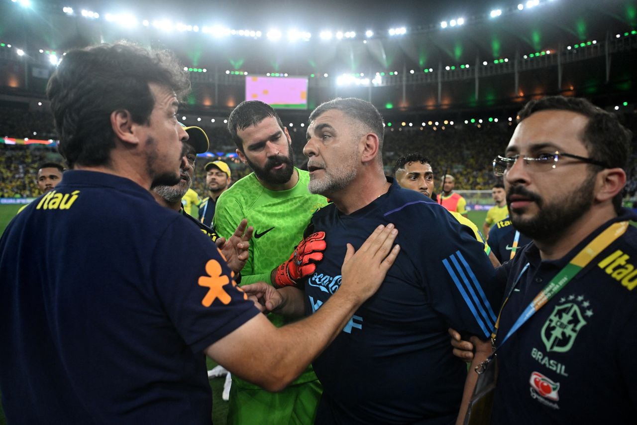 Brazil's coach Fernando Diniz (L) talks with Argentina's physiotherapist Marcelo D'Andrea after clashes erupted on the stands with fans and the Brazilian police before the start of the 2026 FIFA World Cup South American qualification football match between Brazil and Argentina at Maracana Stadium in Rio de Janeiro, Brazil, on November 21, 2023. (Photo by CARL DE SOUZA / AFP)