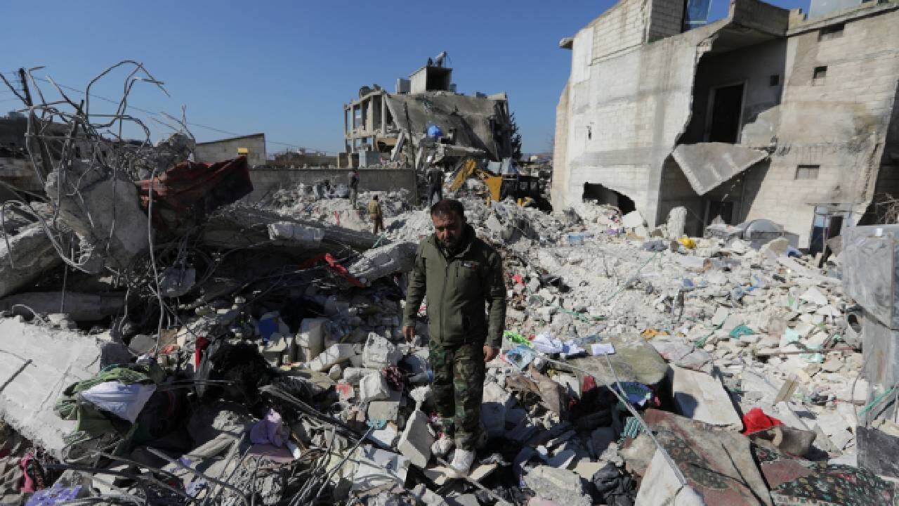 Un sobreviviente del terremoto sobre los escombros de su hogar dañado en la ciudad de Jandaris, Siria.