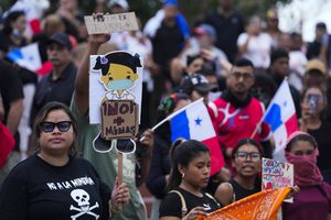 Una manifestante con un cartel en contra de la minería en una protesta convocada contra un contrato aprobado recientemente entre el gobierno y la minera canadiense First Quantum, en Ciudad de Panamá, el miércoles 25 de octubre de 2023. (AP Foto/Arnulfo Franco)